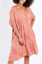 Model Schanez wearing the Chic Dress in colour Corasplash (Pink), from the front, cropped image