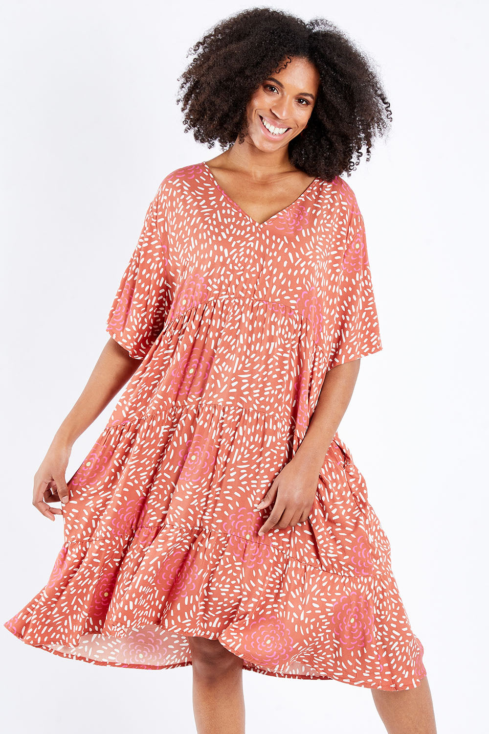 Model Schanez wearing the Chic Dress in colour Corasplash (Pink), from the front, cropped image