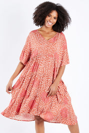 Model Schanez wearing the Chic Dress in colour Corasplash (Pink), from the front, cropped image