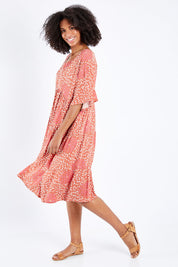 Model Schanez wearing the Chic Dress in colour Corasplash (Pink), from the front, showing the whole outfit