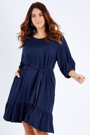 Model Laura wearing the Flare Dress in colour Navy (Blue), from the front, cropped image