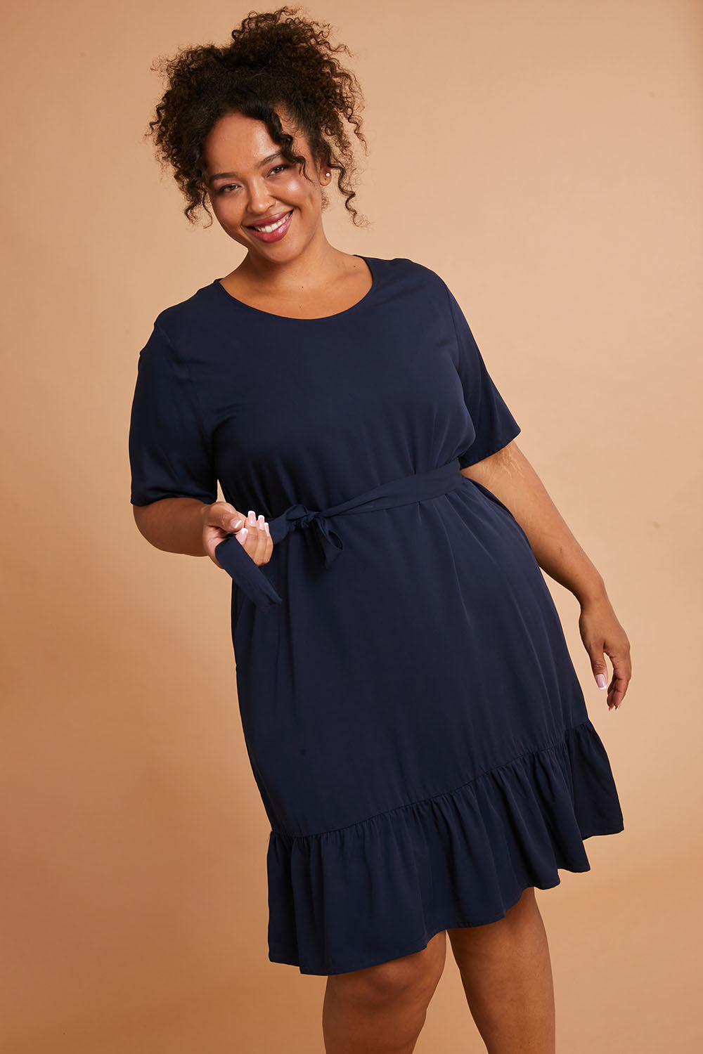 Model Alexis wearing the Short Sleeve Flare Dress in colour Navy (Blue), from the front, cropped image