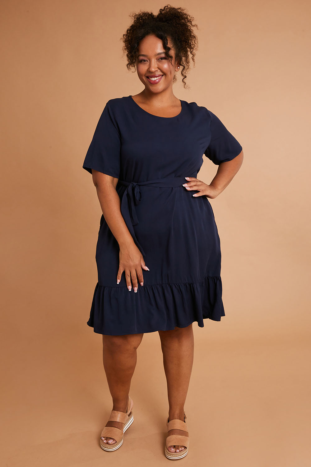 Model Alexis wearing the Short Sleeve Flare Dress in colour Navy (Blue), from the front, showing the whole outfit