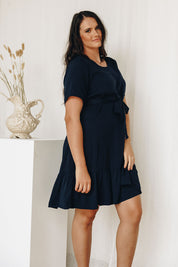 A model wearing the Short Sleeve Flare Dress in colour Navy (Blue), from the front, showing the whole outfit