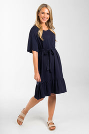 A model wearing the Short Sleeve Flare Dress in colour Navy (Blue), from the front, showing the whole outfit