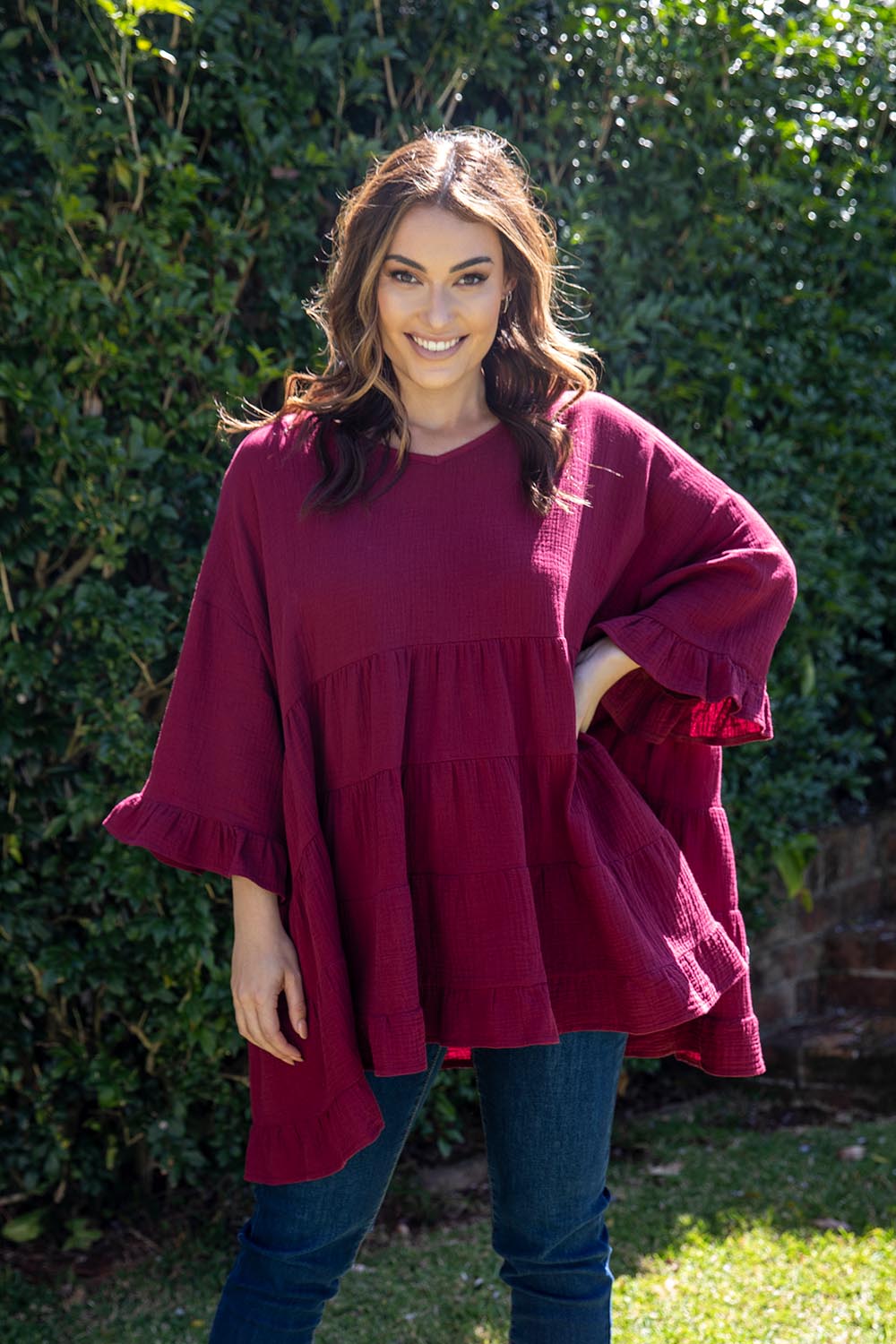 A model wearing the Sofia Top in colour Mahogany (Pink), from the front, showing the whole outfit