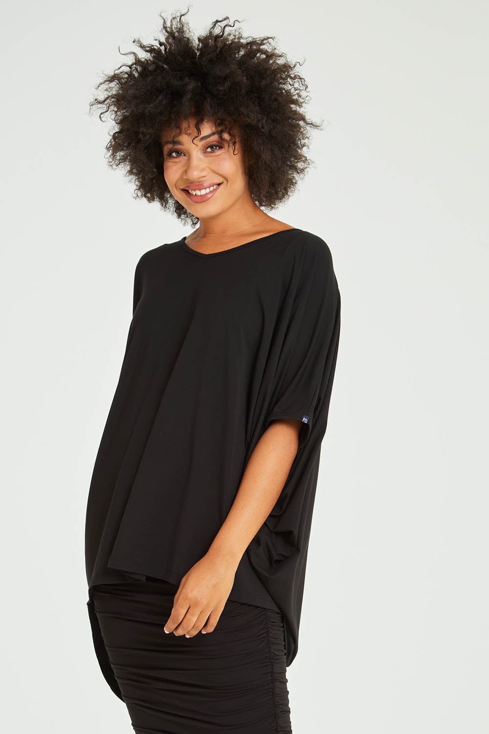 Model Olivia wearing size OneSize of the Hi Low Top in colour Black (Black), from the front, cropped image