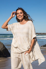 A model wearing the Beachy Top in colour Beige, from the front, showing the whole outfit