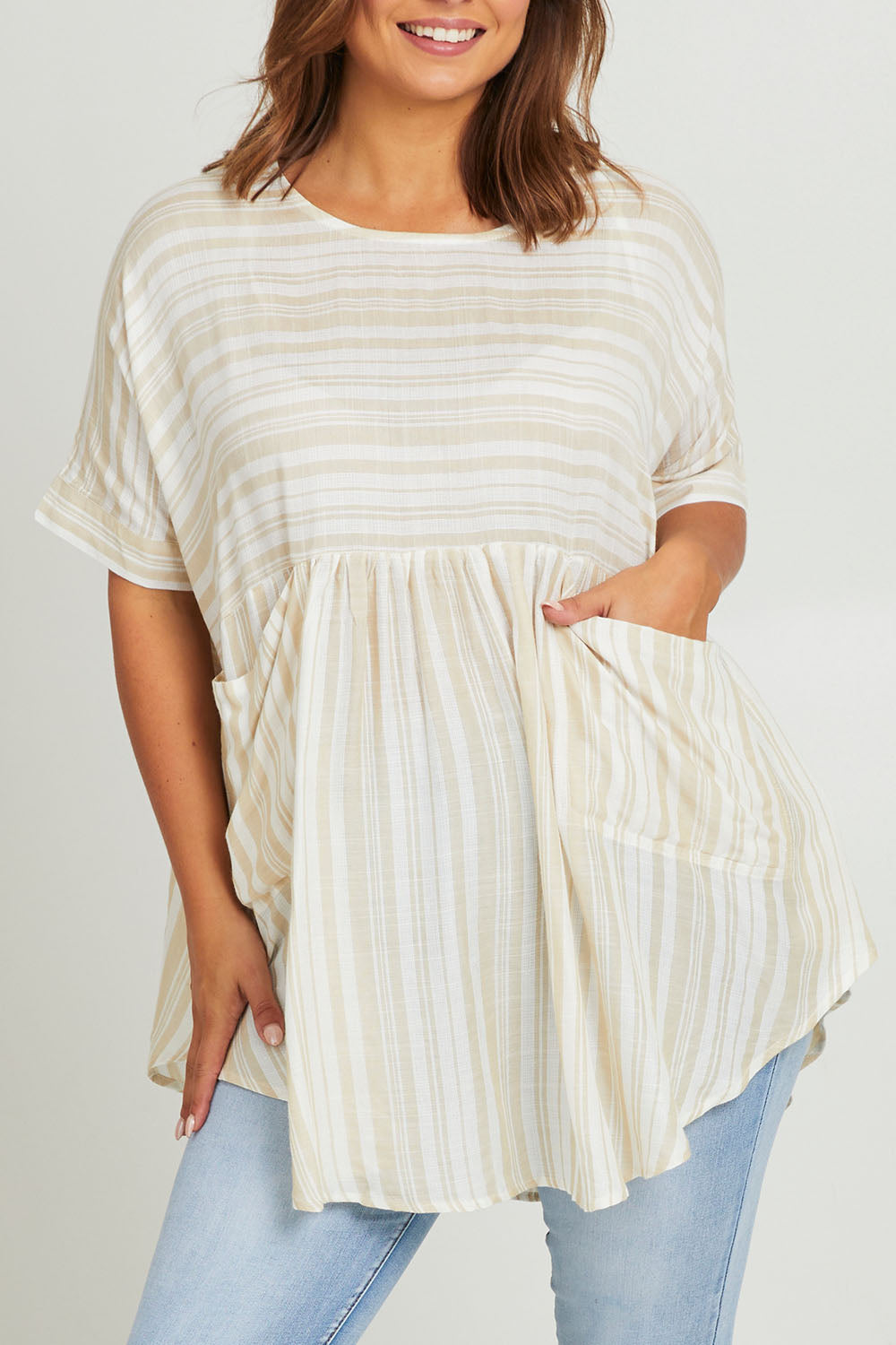 Model Monique wearing the Beachy Top in colour Beige, from the front, cropped image