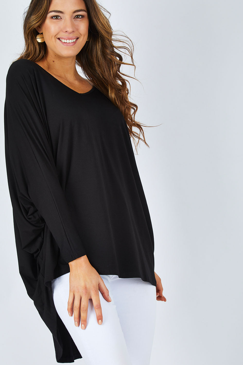 Model Madeline wearing size OneSize of the Long Sleeve Hi Low Top in colour Black (Black), from the front, cropped image