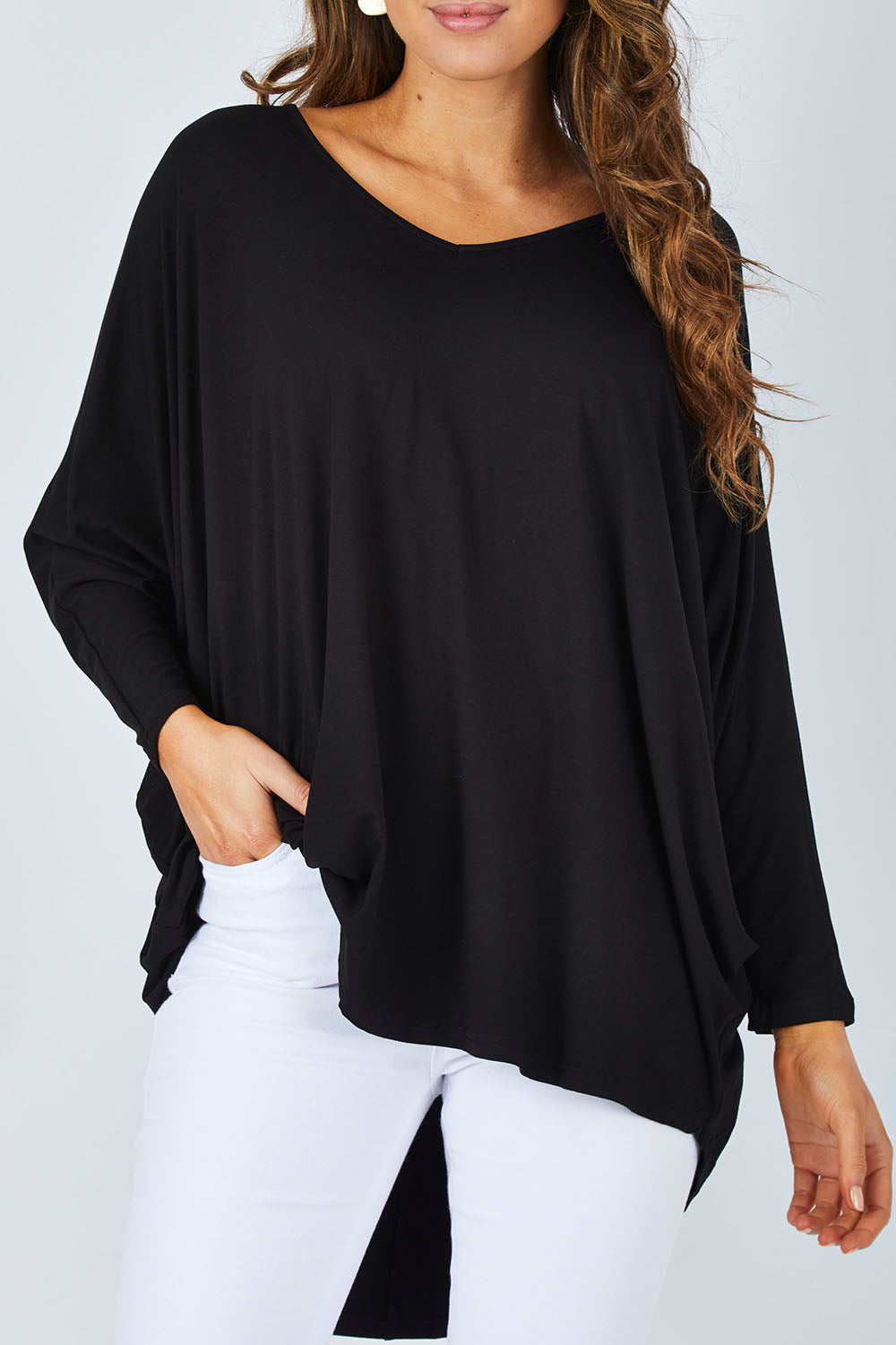 Model Madeline wearing size OneSize of the Long Sleeve Hi Low Top in colour Black (Black), from the front, cropped image