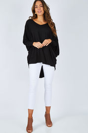 Model Madeline wearing size OneSize of the Long Sleeve Hi Low Top in colour Black (Black), from the front, showing the whole outfit