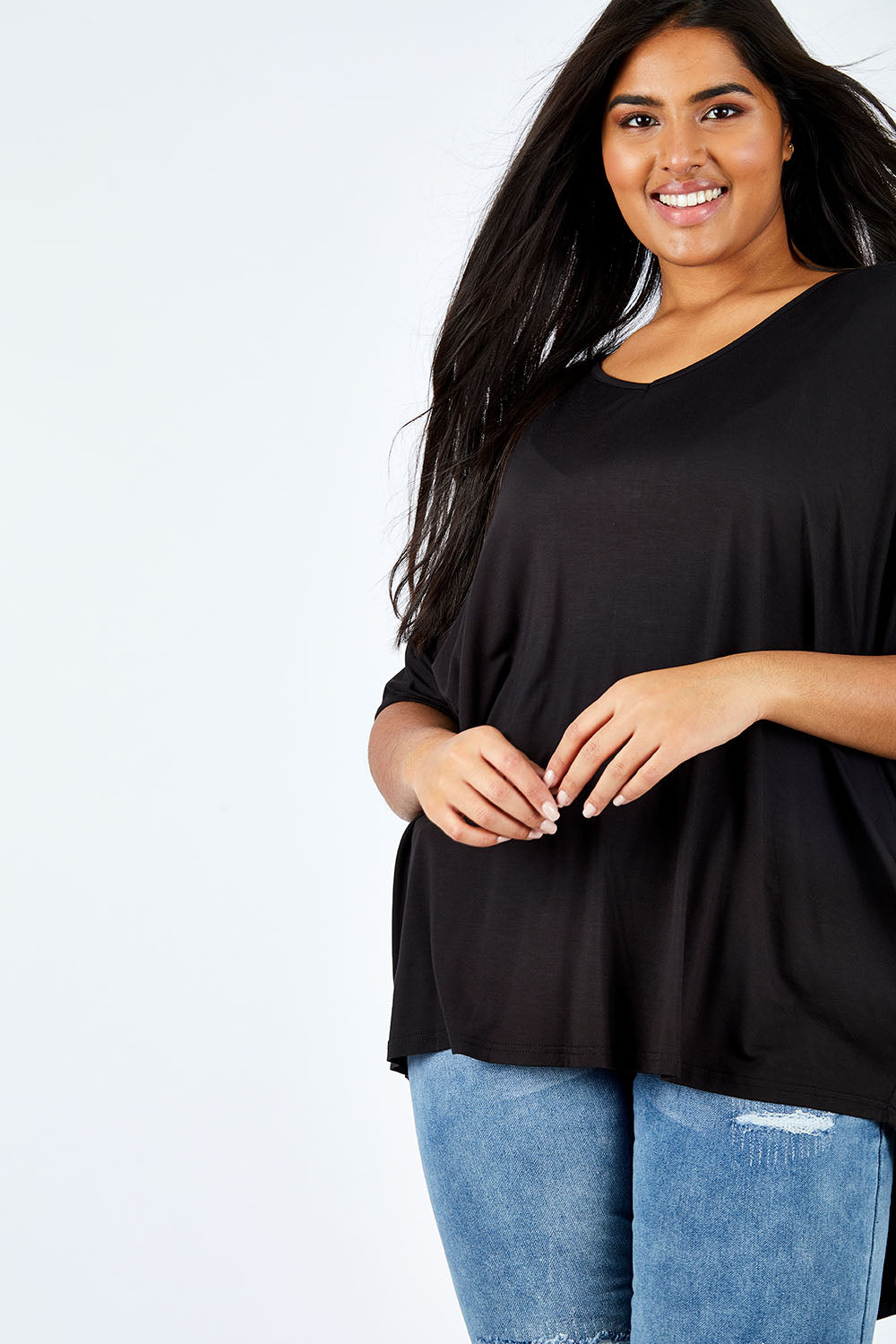 Model Shanaya wearing size OneSize of the Long Sleeve Hi Low Top in colour Black (Black), from the front, cropped image
