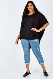 Model Shanaya wearing size OneSize of the Long Sleeve Hi Low Top in colour Black (Black), from the front, showing the whole outfit