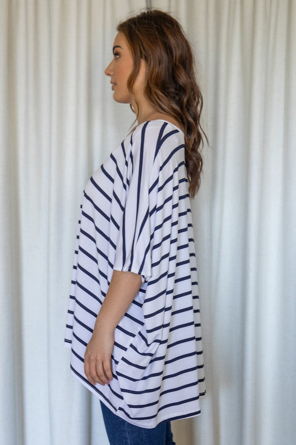 A model wearing the Nice Top in colour Stripe (White), from the front, cropped image
