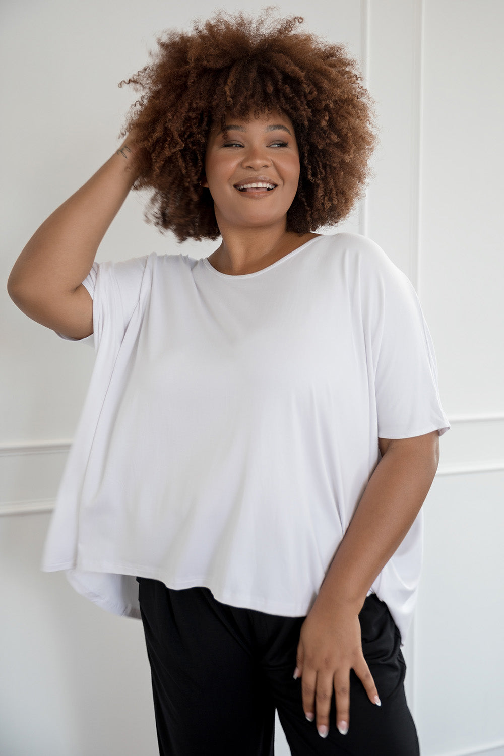 A model wearing the Nice Top in colour White (White), from the front, cropped image