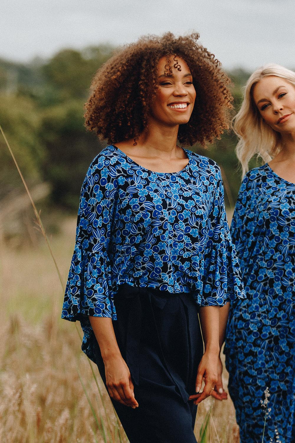 A model wearing the Frill Top in colour Bluegum (Blue), from the front, showing the whole outfit