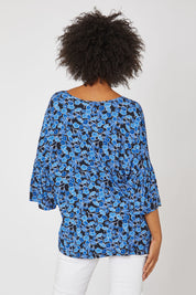 Model Olivia wearing the Frill Top in colour Bluegum (Blue), from the back