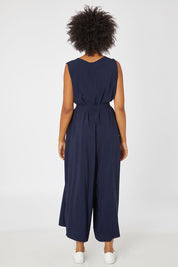 Model Olivia wearing the Button Down Jumpsuit in colour Navy (Blue), from the back