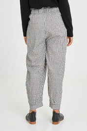 Model Olivia wearing size S of the Archer Pant in colour Nightcheck (Blue), from the back