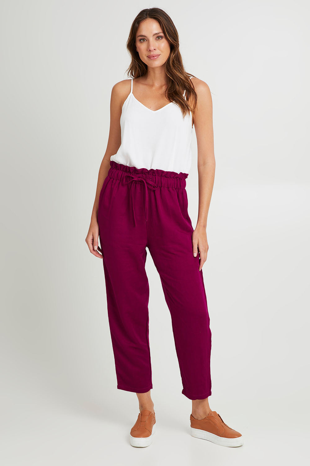 Model Madeline wearing size S of the Olivia Pant in colour Deepplum (Pink), from the front, showing the whole outfit