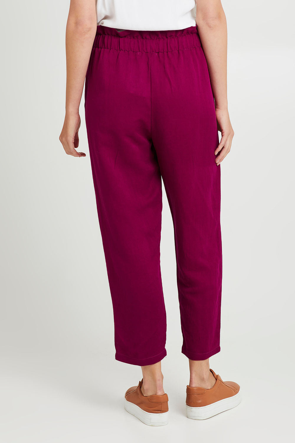 Model Madeline wearing the Olivia Pant in colour Deepplum (Pink), from the back