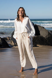 A model wearing the Olivia Pant in colour Beige, from the front, showing the whole outfit