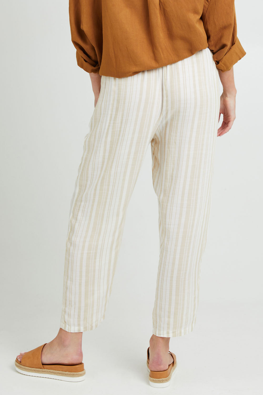 Model Grace wearing size S of the Olivia Pant in colour Beige, from the back