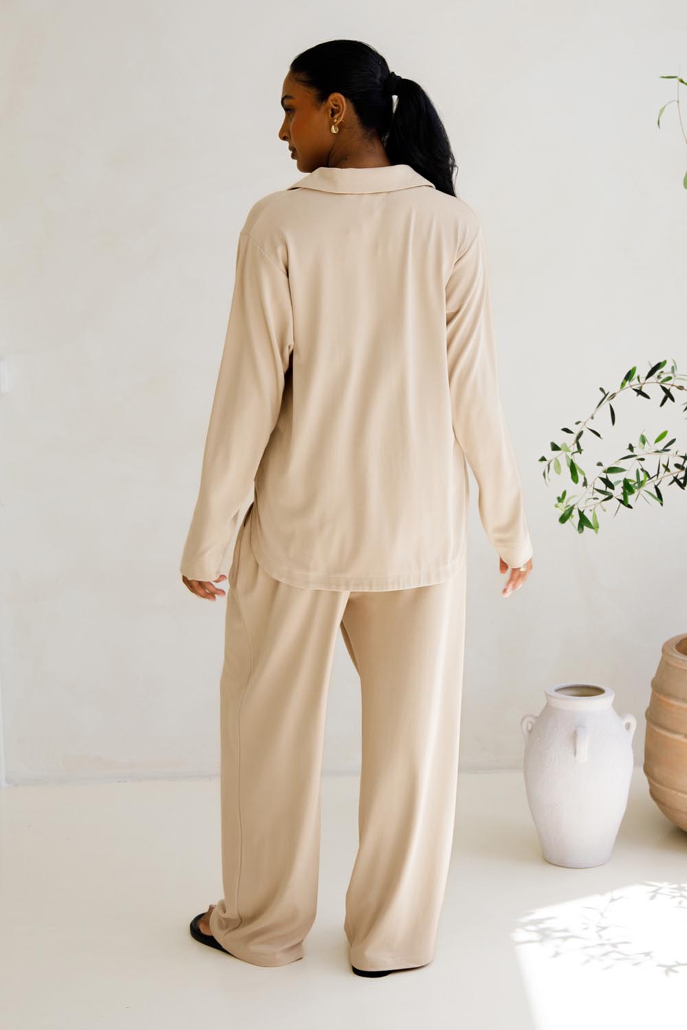 A model wearing the Gigi Lounge Pant in colour Portobeige, from the back