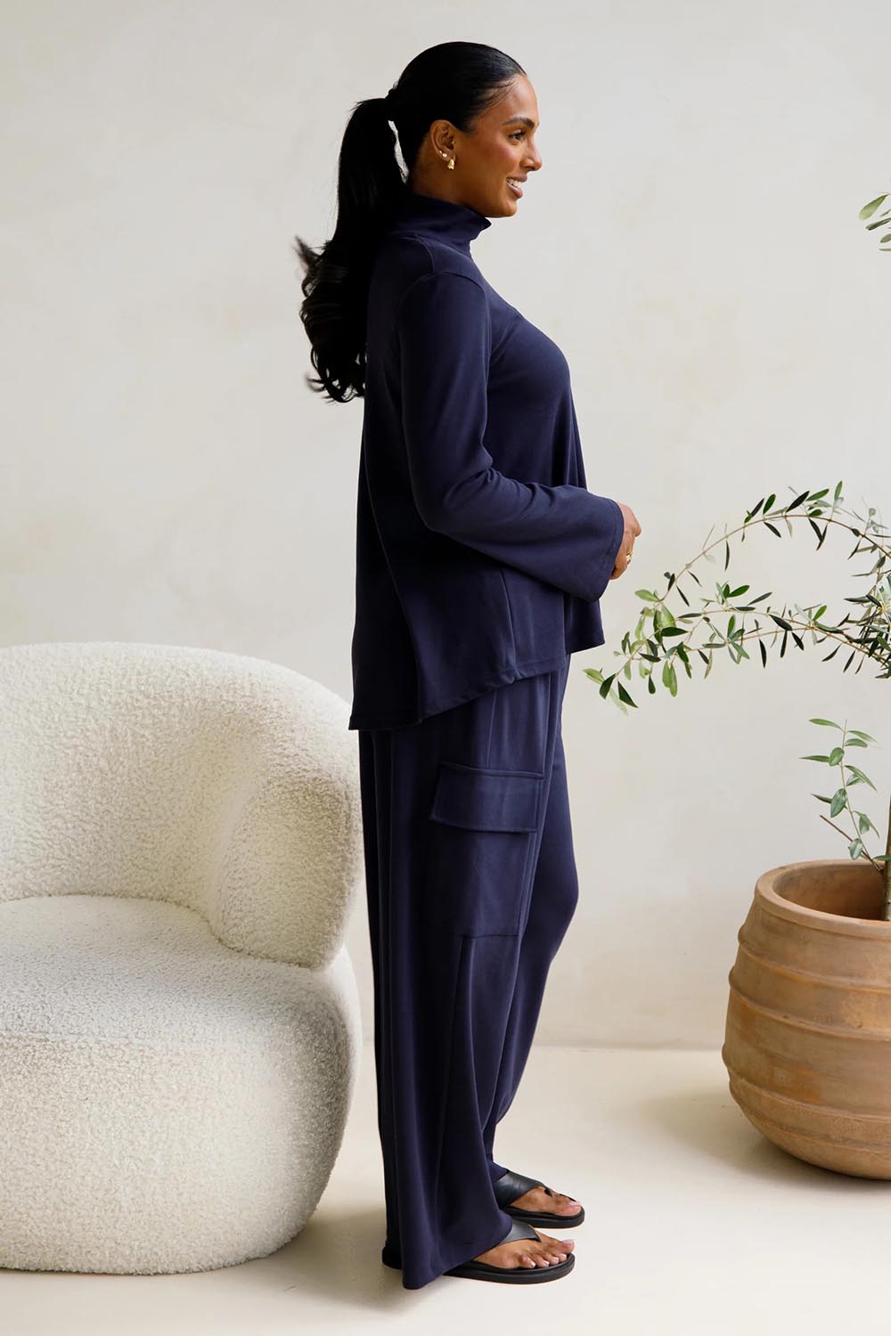 A model wearing the Eden Cotton Blend Pants in colour Midnight (Blue), from the front, showing the whole outfit