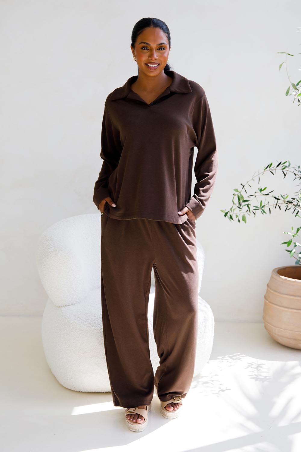 A model wearing the Gigi Lounge Sweater in colour Chocolate, from the front, showing the whole outfit