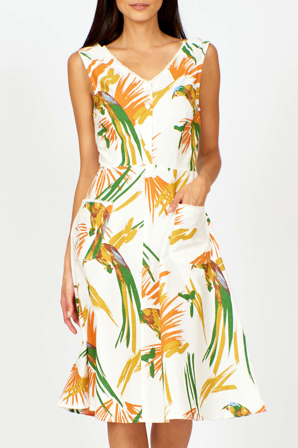 A model wearing the Harriet Dress in colour Parrot (White), from the front, cropped image