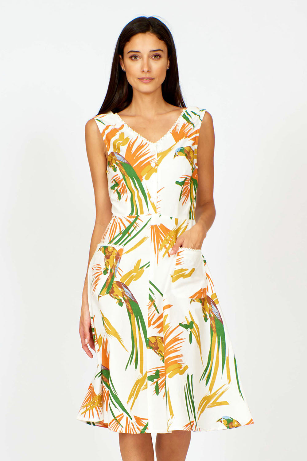 A model wearing the Harriet Dress in colour Parrot (White), from the front, cropped image