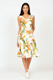 A model wearing the Harriet Dress in colour Parrot (White), from the front, showing the whole outfit