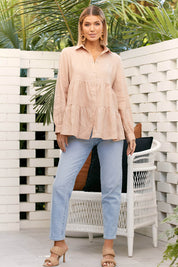 A model wearing the Eliza Linen Tiered Long Shirt in colour Nude, from the front, showing the whole outfit
