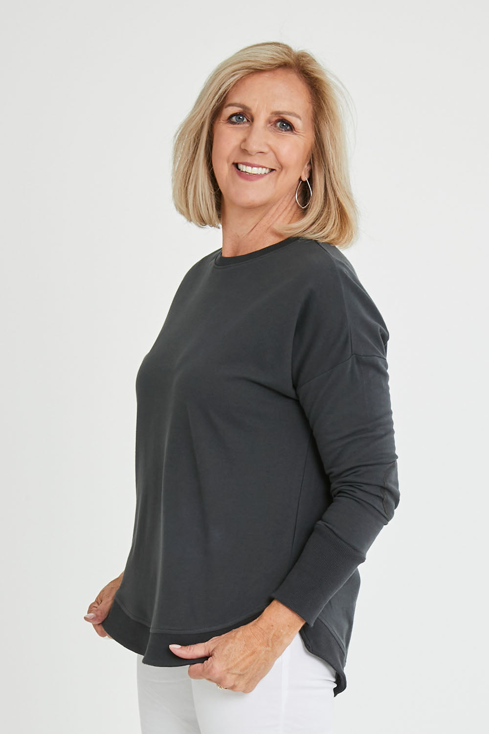 Model Sandy wearing size 10 of the Lucy French Terry Sweat in colour Gunmetal (Grey), from the front, cropped image