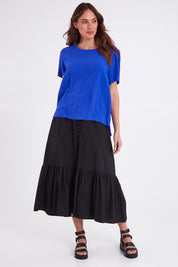 Model Madeline wearing size 10 of the Sangria Top in colour Decoblue (Blue), from the front, showing the whole outfit