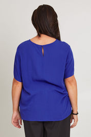 Model Poppy wearing size 16 of the Sangria Top in colour Decoblue (Blue), from the back
