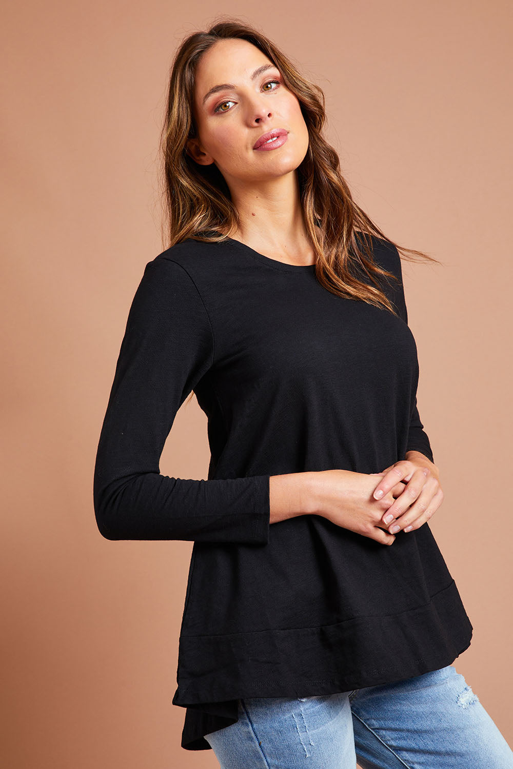 Model Madeline wearing size 10 of The Long Sleeve Swing Tee in colour Black (Black), from the front, showing the whole outfit