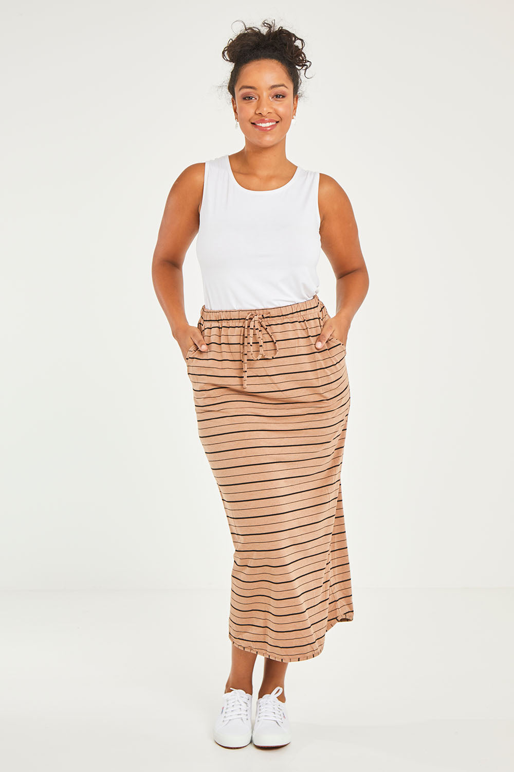 Model Noli wearing size 14 of The Pull On Maxi Skirt in colour Camelblack (Black), from the front, showing the whole outfit