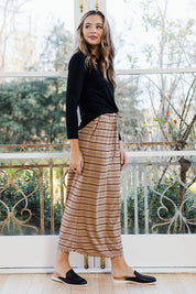 Model Tahlia wearing size 10 of The Pull On Maxi Skirt in colour Camelblack (Black), from the front, showing the whole outfit