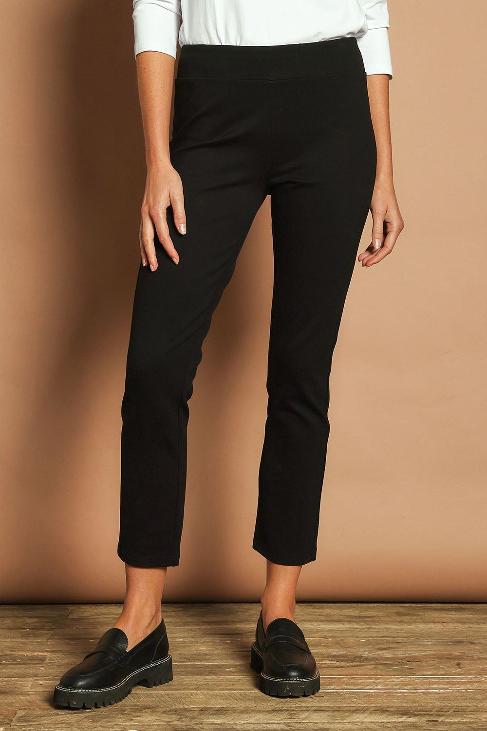 Model Madeline wearing size 10 of The Straight Leg Ponte Pant in colour Black (Black), from the front, cropped image