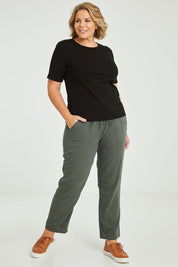 Model Fiona wearing size 16 of The Easy Wear Pant in colour Ashgreen (Green), from the front, showing the whole outfit