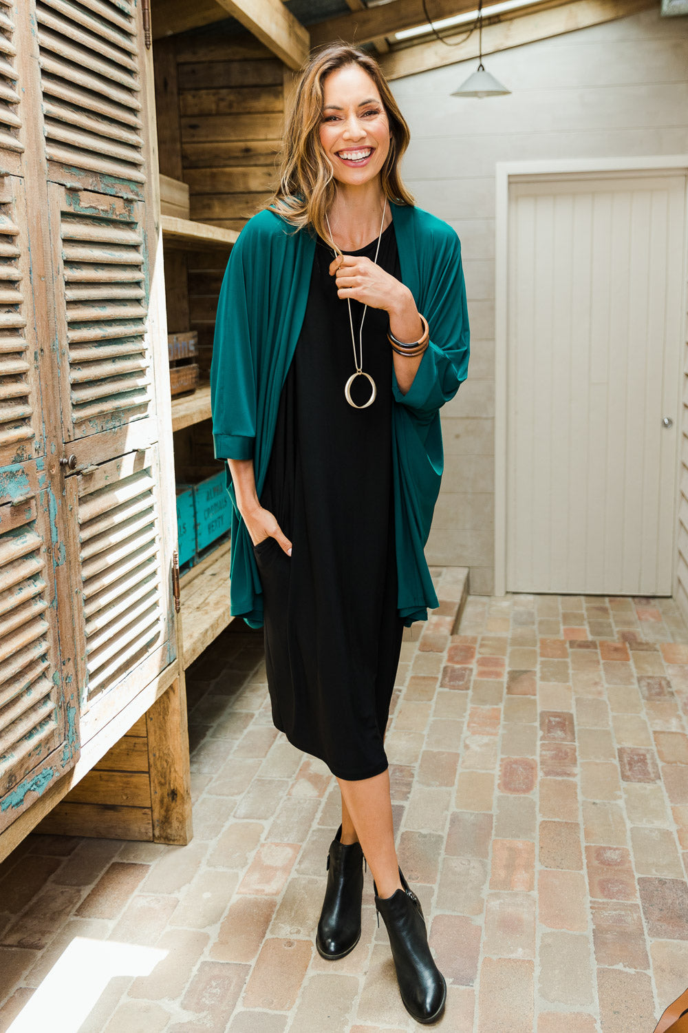 Model Amanda wearing size 10 of The Recycled Relax Fit Cardi in colour Deeplagoon (Green), from the front, showing the whole outfit