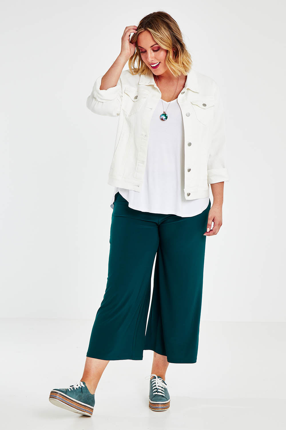 Model Jess wearing size 14 of The Recycled Relax Fit Pant in colour Deeplagoon (Green), from the front, showing the whole outfit