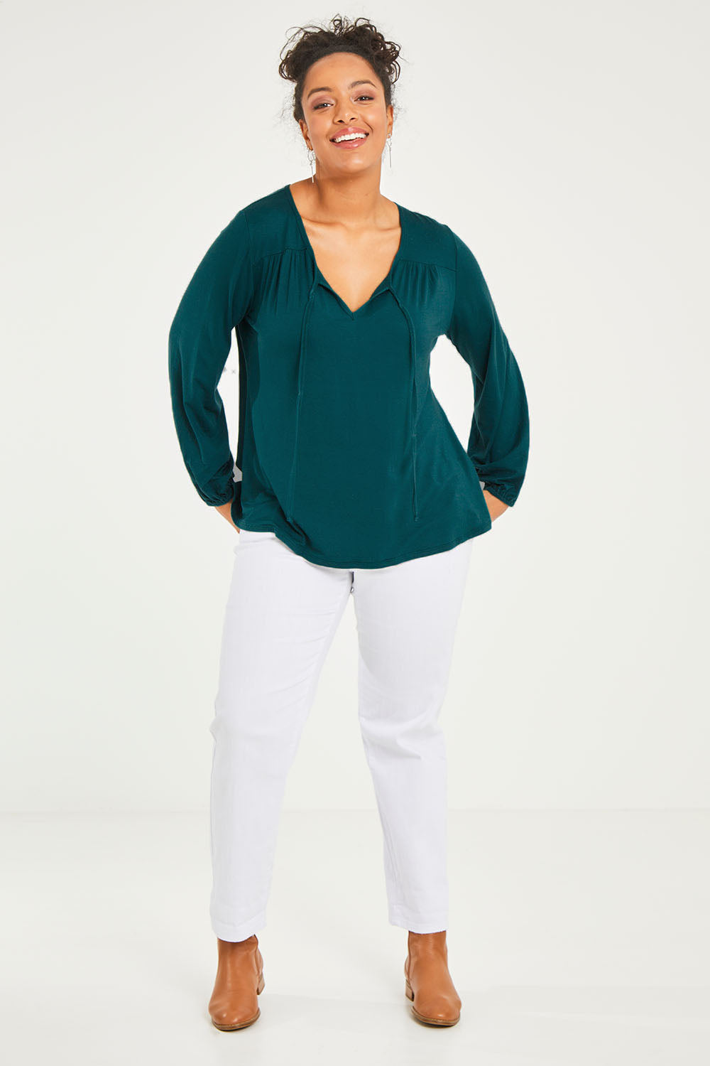 Model Terri-Leigh wearing size 14 of the Preloved The V Neck Tie Top in colour Juniper (Green), from the front, showing the whole outfit