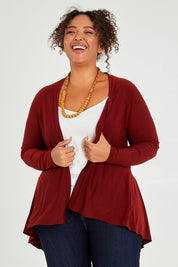 Model Alexis wearing size 16 of The Recycled Flounce Cardigan in colour Terracotta, from the front, cropped image