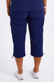 Model Monique wearing size 14 of The Everyday Cropped Cargo Pant in colour Frenchblue (Blue), from the back