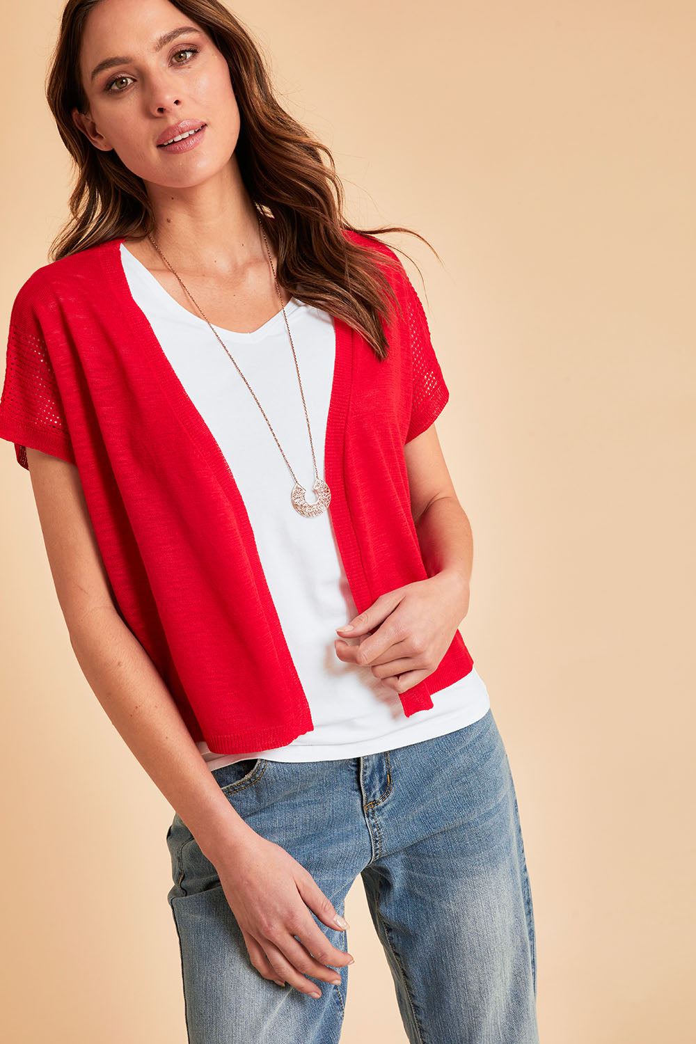 Model Madeline wearing size S of The Short Sleeve Shrug in colour Red (Red), from the front, showing the whole outfit