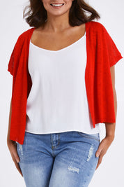 Model Monique wearing size L of The Short Sleeve Shrug in colour Red (Red), from the front, cropped image